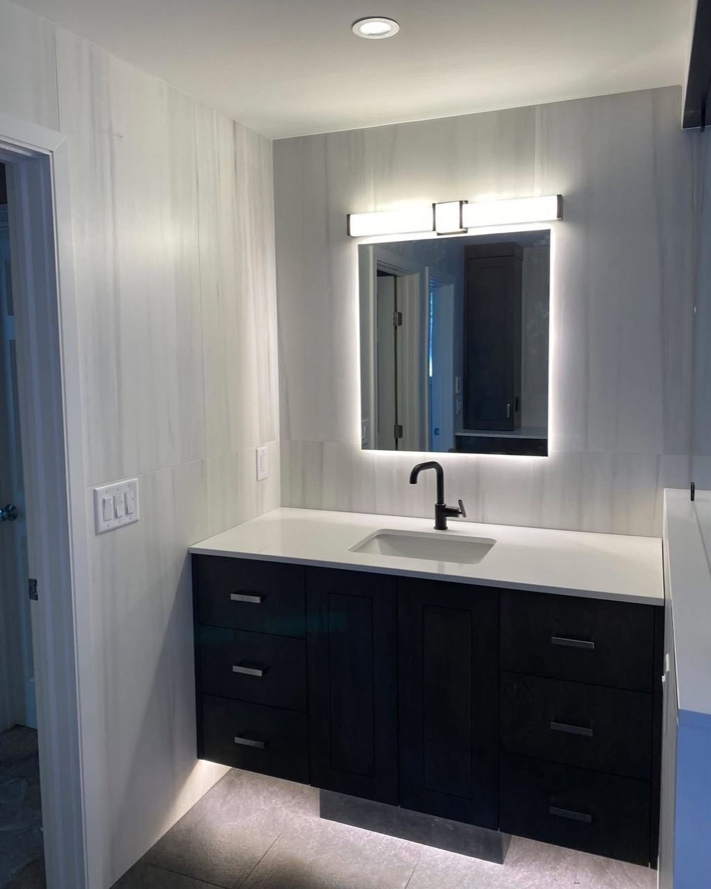 Bathroom vanity lighting and backlit mirror installed by Full Circuit Electrical Solutions.